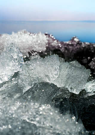 Stacked ice with sea and purple sky in backgroundの写真素材