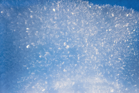 Blue background with ice crystals in snowの写真素材