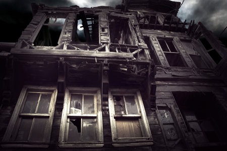 Spooky wooden building on moody night sky with moonの写真素材