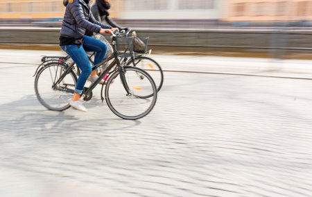 Two young women on bikes in blurred motion