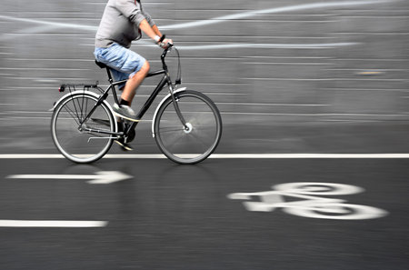 cyclist on black bike with smooth gray blurred background