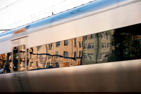 Urban buildings reflected in windows of train in blurred motion