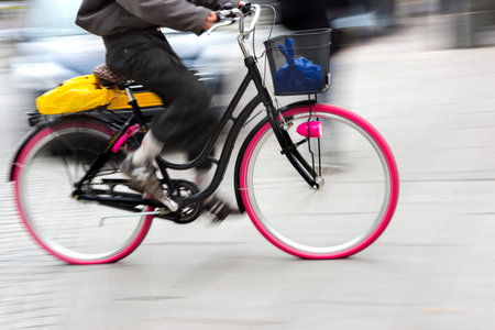 Person cycling on bike with pink wheels in blurred motionのeditorial素材