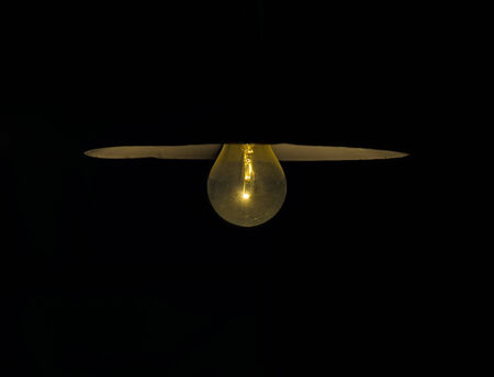 Close up of old lamp with old fashioned light bulb on blackの写真素材