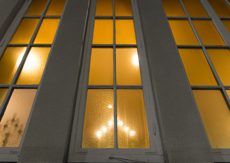 Low angle view of church window with light and candlestick insideの写真素材