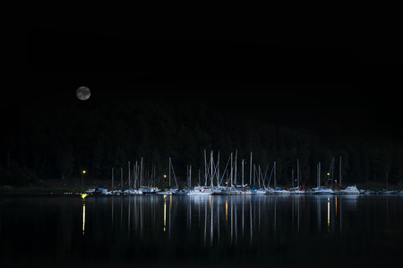 Evening shot of yachts and other small boats moored by small island in Swedish archipelagoの写真素材