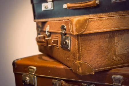Heap of worn vintage leather suitcases in sepia toneの写真素材