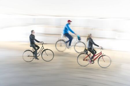 Three cyclists in blurred motion on smooth backgroundの写真素材