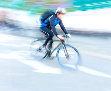 cyclist at high speed on racing bike with blue wheels tires in blurred motion