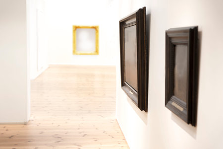 Two vintage picture frames on wall in art museum