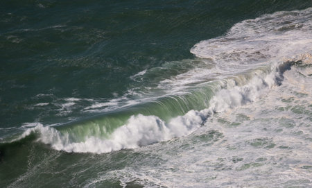 Beautiful powerful green wave with froth in sea seen from above