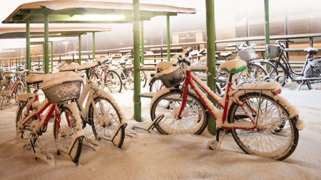 Red bike in bicycle park during snow stormの写真素材