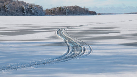 Tyre tracks in melting snow on ice on lakeの写真素材
