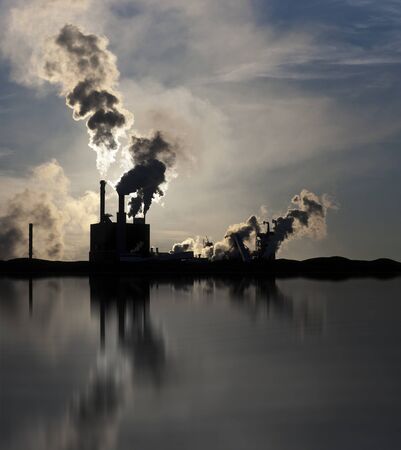 Factory polluting the environment, reflected in waterの写真素材