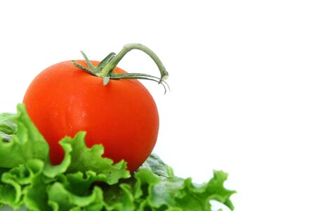 Close up of a red tomato on lettuce on a white backgroundの写真素材