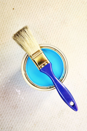 Blue painting in a container with a brush on top