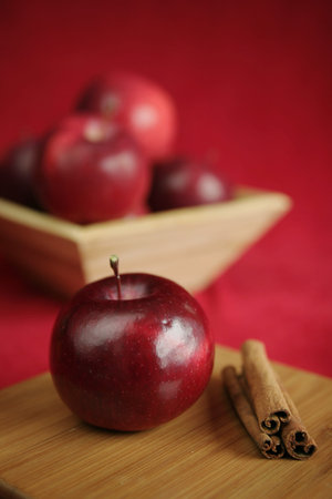 fresh red apple with a basket full of red apple in backgroundの写真素材