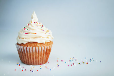 Vanilla cup cake with white icing and candies on top