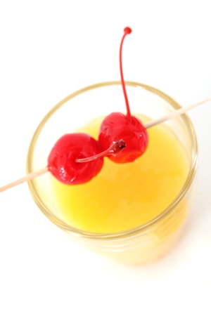 Fresh orange juice with cherries on topの写真素材