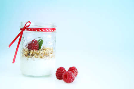 Clear bowl with vanilla yogurt, mint, raspberry and muesliの写真素材