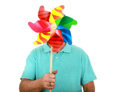 Man holding a pinwheel in front of his face on a white backgroundの写真素材
