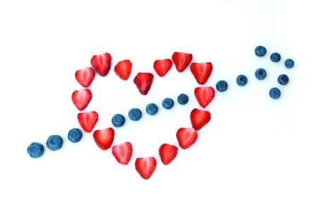 Heart made with fresh strawberries and an arrow made with blueberry.の写真素材