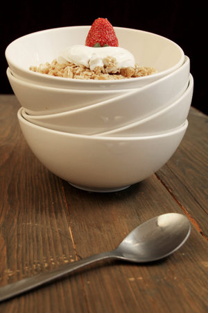 Cereals with yogurt and strawberry in a stack of bowls