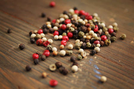 Mixed pepper corn on a wooden cut boardの写真素材