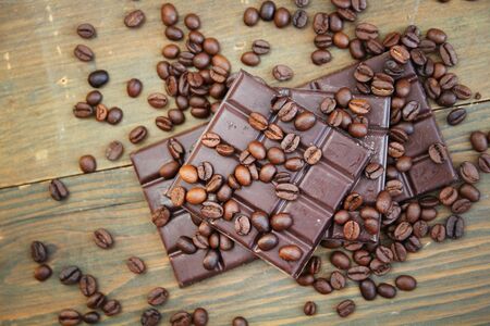 Dark chocolate and coffee beans on a wooden table の写真素材