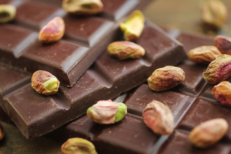 Dard chocolate and pistachios on a wooden table 