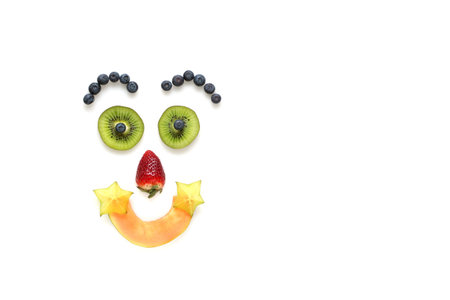 Happy face made with an arrangement of  fruits on a white background