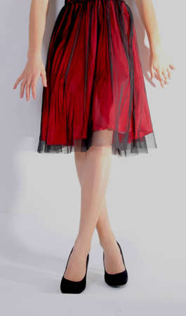 bottom of a woman wearing red dress and black velvet shoesの写真素材