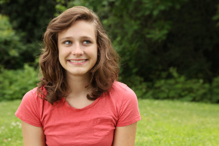 Smiling teenager lying on a grass in a park
