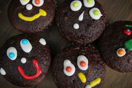 Chocolate cupcake with little face on a wooden table