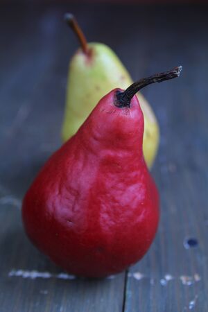 Red bartlett pears and yellow pear on a wooden tableの写真素材