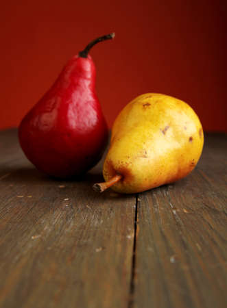 Red bartlet pears and yellow pear on a wooden tableの写真素材