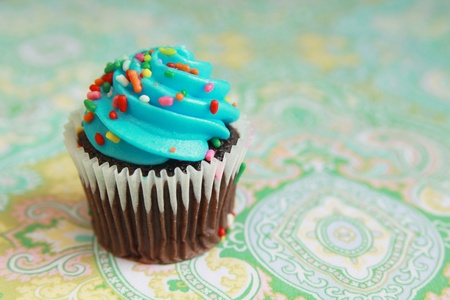 Chocolate cupcake with blue icing and candiesの写真素材