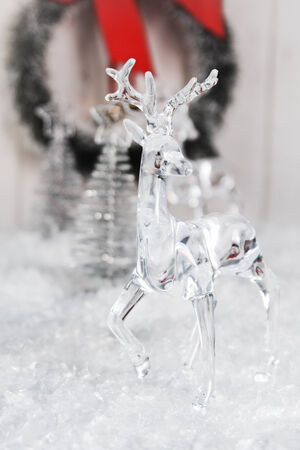 Transparent deer decoration with silver christmas trees in background の写真素材