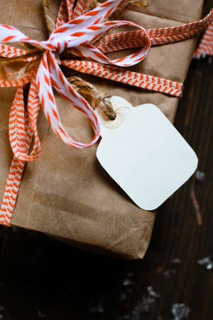 Ecologic gift wrap with kraft paper, red bow and christmas bauble with tagの写真素材