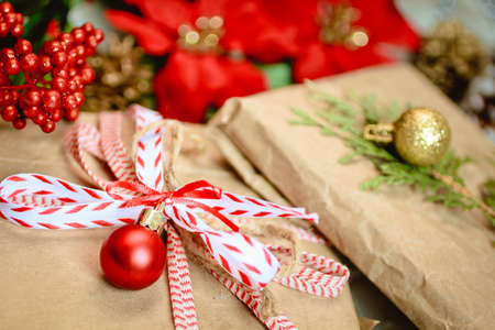 Ecologic gift wrap with kraft paper, red bow and christmas baubleの写真素材