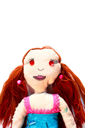 Portrait of a handmade doll with red hair on a white backgroundの写真素材