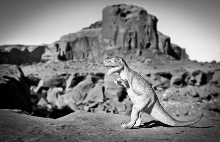 Black and white picture with a dinosaur and Monument Valley in backgroundの写真素材