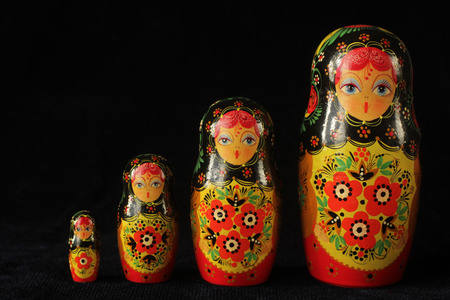 Three different kind of pepper, red, orange and yellow on a fork on a black backgroundの写真素材