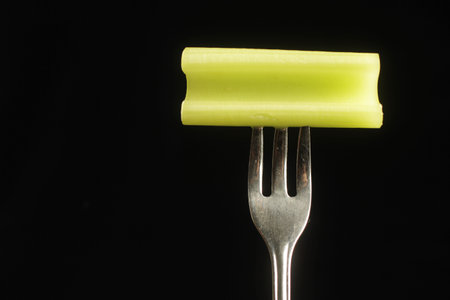 Celery on a fork on a black background