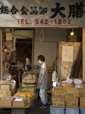 TOKYO-JAPAN, 27 June 2016: Japanese woman with mask in a store at tsukiji, fish market in Tokyo, Japan.  The biggest wholesale fish and seafood market in the world.のeditorial素材
