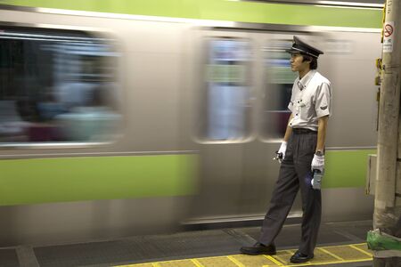 TOKYO-JAPAN, 27 June 2016:  Train controller at the JR train station and fast moving train. It is one of Tokyo's busiest and most important lines in Tokyo, Japan.のeditorial素材