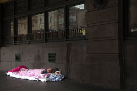MELBOURNE, AUSTRALIA - OCTOBER 14, 2016:  Young homeless man sleeping in a pink sleeping bag on pavement.  Record numbers of homeless people sleeping on Melbourne's streets.のeditorial素材
