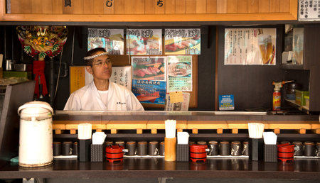 TOKYO-JAPAN, 27 June 2016: Japanese man standing in his restaurant at tsukiji fish market in Tokyo, japan. The biggest wholesale fish and seafood market in the world.のeditorial素材