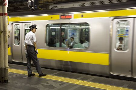 TOKYO-JAPAN, 27 June 2016:  Train controller at the JR train station and fast moving train. It is one of Tokyo's busiest and most important lines in Tokyo, Japan.のeditorial素材