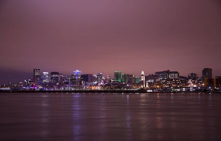 MONTREAL CANADA AUGUST 20: Reflection light in the water, in front of port of Montreal, and downtown in background at night with a pink tone.のeditorial素材
